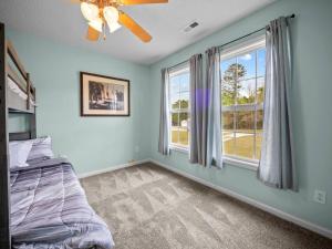 a bedroom with blue walls and a bed and a window at Freedom's Stay at Liberty Hills in Jacksonville