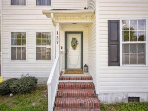a white house with stairs leading to the front door at Freedom's Stay at Liberty Hills in Jacksonville