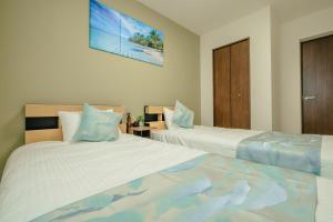 2 Betten in einem Hotelzimmer mit 2 Betten sidx sidx sidx sidx in der Unterkunft Value Residence 与那覇 プール 無料レンタカー付 in Miyako-jima + 43 Fotos