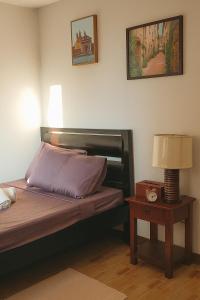 ein Schlafzimmer mit einem Bett und einem Tisch mit einer Lampe in der Unterkunft Heritage-Inspired Home in the Heart of Vigan in Sampong