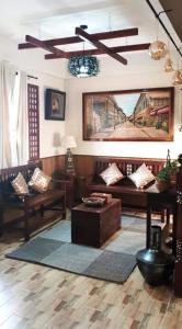 ein Wohnzimmer mit Sofas und einer Decke in der Unterkunft Heritage-Inspired Home in the Heart of Vigan in Sampong