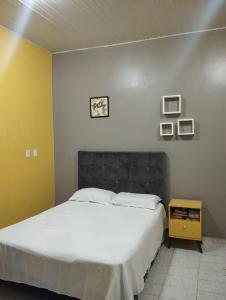 a bedroom with a large bed and a yellow wall at Acomodação aconchegante COP-30 Belém in Belém
