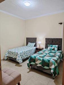 Un dormitorio con dos camas y una silla. en Departamento Shalom, en Tarija