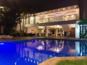 a swimming pool in front of a building at night at Samiria Jungle Hotel in Iquitos