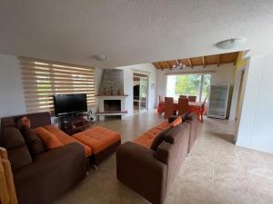 a living room with couches and a flat screen tv at Hermosa casa campestre rodeada de naturaleza y comodidad in Malchinguí