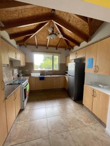 a kitchen with wooden cabinets and a black refrigerator at Hermosa casa campestre rodeada de naturaleza y comodidad in Malchinguí
