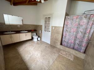 a bathroom with two sinks and a shower curtain at Hermosa casa campestre rodeada de naturaleza y comodidad in Malchinguí
