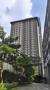 a tall building with trees in front of it at Ascott Menteng Jakarta in Jakarta