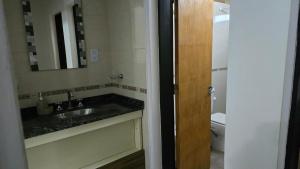 Un baño con lavabo, espejo e inodoro. en Hogar Lejano Cabañas y Río - Huerta Grande - Sierras de Córdoba, en Huerta Grande 24 fotos más
