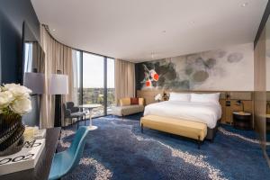 a hotel room with a bed and a desk at Novotel Sydney Cabramatta in Cabramatta +32 photos