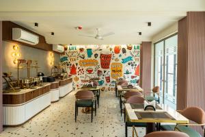 a restaurant with tables and chairs and a wall covered in graffiti at Hotel City Pride in Mahuva