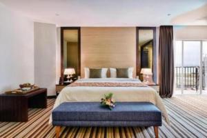ein großes Schlafzimmer mit einem großen Bett und einer blauen Bank in der Unterkunft Goldsands Hotel Langkawi in Kuah
