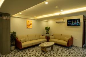a lobby with couches and a table in a room at Hotel City Pride in Mahuva