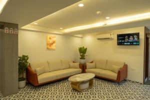 a waiting room with two couches and a table at Hotel City Pride in Mahuva +19 photos