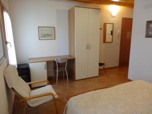 ein Schlafzimmer mit einem Bett, einem Schreibtisch und einem Tisch in der Unterkunft Cà Francine in Gruaro