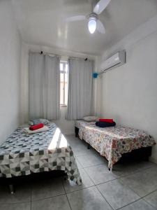 a bedroom with two beds and a window at Quarto Privado Cama Casal ou Individual Aeroporto in Rio de Janeiro