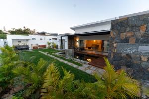 an exterior view of a house with a garden at Nilaya Villa by Swarga Mauritius in Cap Malheureux