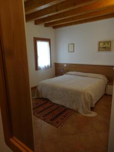 Schlafzimmer mit einem Bett und einem Fenster in der Unterkunft Cà Francine in Gruaro