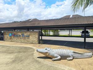 a statue of a alligator in front of a building at Vi Homelite Resort Airport in Miri