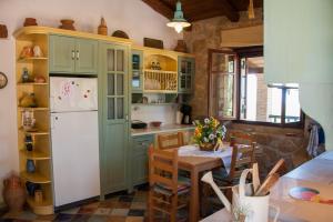 a kitchen with green cabinets and a table and a refrigerator at Villa Collina in Vasilikos