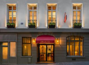 een gevel van een hotel met een rode luifel bij Hôtel Saint-Paul Rive-Gauche in Parijs