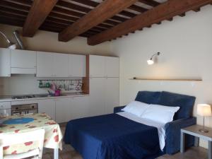 1 dormitorio con 1 cama azul y cocina en Agriturismo Valdappio, en Urbino
