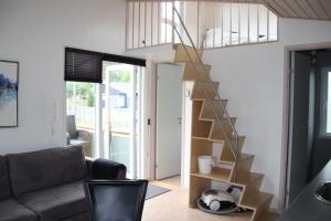 a living room with a staircase in a tiny house at Læsø Camping & Hytteby in Vesterø Havn