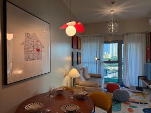 a living room with a table and a couch at Modern 1BR with Balcony Facing Infinity Pool Manila Bay Sunset Near Airports OKADA Solaire MOA in Manila