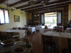 ein Restaurant mit Tischen und Stühlen mit weißen Tischdecken in der Unterkunft Cà Francine in Gruaro