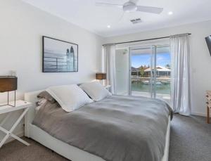 a bedroom with a bed and a large window at Port Sails Escape in Mandurah