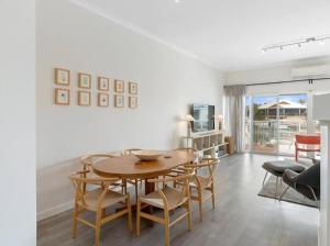 a living room with a wooden table and chairs at Port Sails Escape in Mandurah