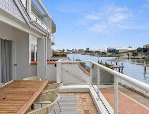 a balcony of a house with a table and chairs at Port Sails Escape in Mandurah