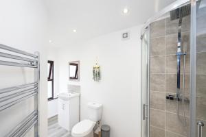 a bathroom with a toilet and a shower at Spacious & Stylish 5 Bed with Free Street Parking in Morecambe +12 photos