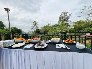 a table with bowls and plates of food on it at Cabin Alpha in Bandarawela
