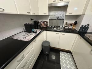 a kitchen with white cabinets and a black counter top at Casa Blanca Haymarket in Sydney