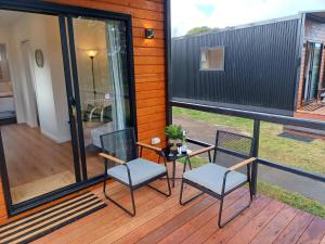 a screened in porch with two chairs and a table at BIG4 Stratford Caravan Park in Stratford +8 photos