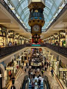 a clock tower in a shopping mall with a crowd of people at Casa Blanca Haymarket in Sydney