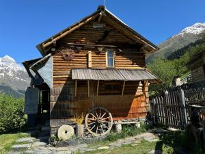 a wooden house with a large wheel in front of it at Ipderi cottages in Lekhtagi