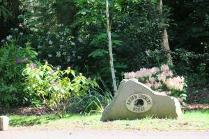 Una roccia seduta nell'erba vicino a dei fiori di Arden Country House a Linlithgow