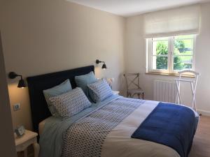 a bedroom with a bed with pillows and a window at La Maison des Belles Filles in Pernand-Vergelesses +16 photos