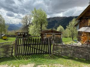 a wooden fence in a field with a house at Ipderi cottages in Lekhtagi