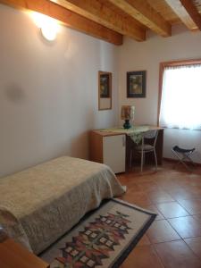 1 dormitorio con cama, escritorio y ventana en Cà Francine, en Gruaro