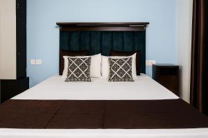a bedroom with a large bed with white sheets and pillows at VVIP Address Homestay Jagatpura Jaipur Luxury Stay in Jaipur