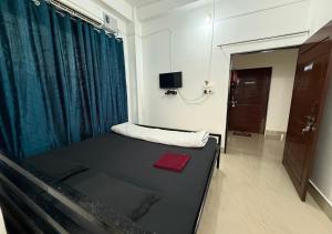a room with a bed and a tv in it at Buvana Lodge in Dudhnai