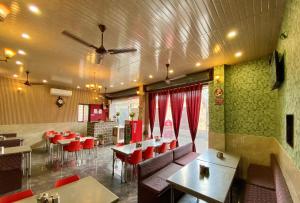 a restaurant with red chairs and tables in a room at Rathore Stays in Udaipur +15 photos