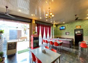 a restaurant with tables and red chairs in a room at Rathore Stays in Udaipur