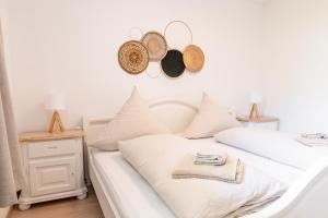 a bedroom with a white bed with hats on the wall at Ferienwohnung Alpenglück in Seeg