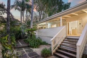 a home with a staircase leading to the front porch at Cove Quarters in Byron Bay