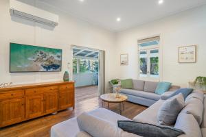 a living room with two couches and a tv at Cove Quarters in Byron Bay