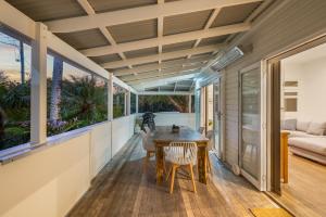 a room with a table and chairs on a balcony at Cove Quarters in Byron Bay